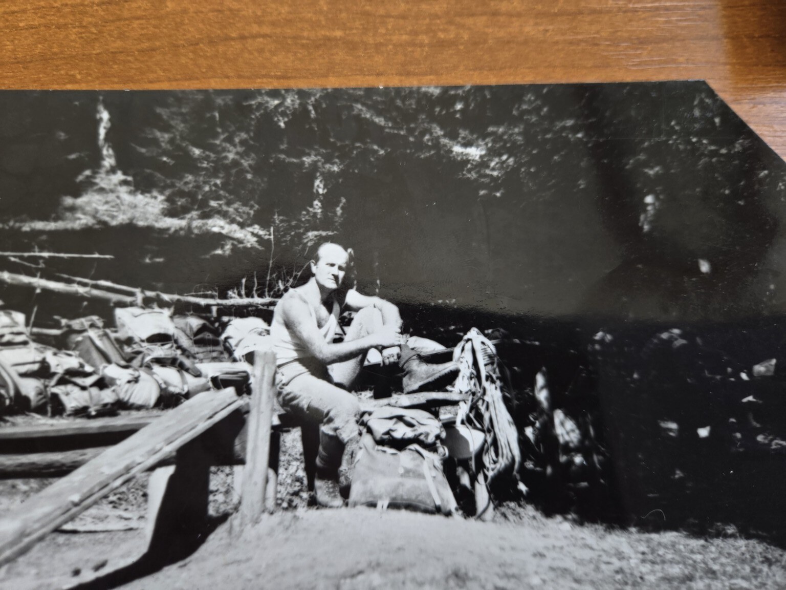 Planinar sjedi među ruksacima i opremom na staroj crno-bijeloj fotografiji